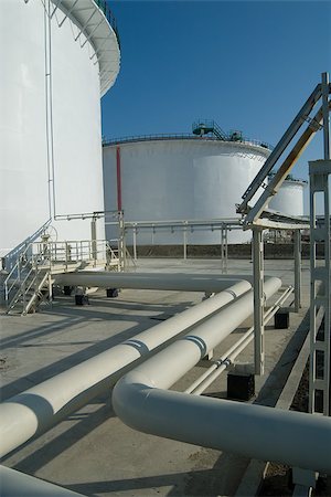 simsearch:400-05728780,k - Petroleum storage reservoires and pipelines are white. Industry object is captured against a blue sky background. Foto de stock - Super Valor sin royalties y Suscripción, Código: 400-07321236