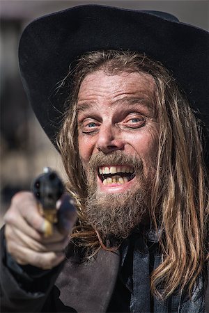 simsearch:400-07516134,k - Cowboy Laughs While He Points Gun at You Stock Photo - Budget Royalty-Free & Subscription, Code: 400-07321473