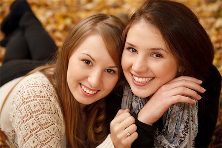 simsearch:400-07303759,k - closeup of  two young females lying down in autumn forest smiling looking at camera Stockbilder - Microstock & Abonnement, Bildnummer: 400-07322808