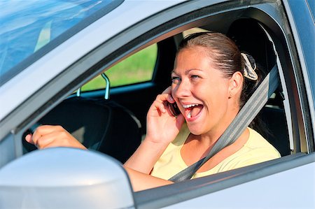 beautiful girl behind the wheel with phone laughing Stock Photo - Budget Royalty-Free & Subscription, Code: 400-07323032