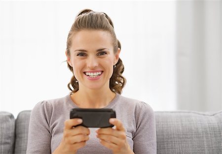 Happy young woman reading sms Stock Photo - Budget Royalty-Free & Subscription, Code: 400-07323586