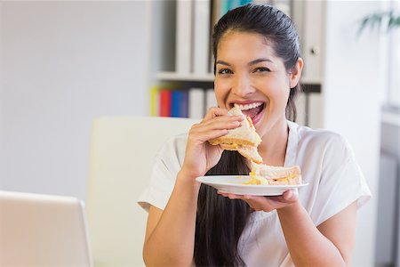 Portrait of happy businesswoman eating sandwich in office Foto de stock - Super Valor sin royalties y Suscripción, Código: 400-07334207