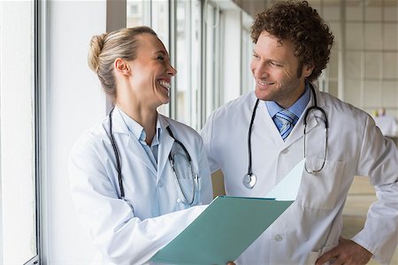 simsearch:400-07334526,k - Happy doctors discussing over file on hospital Stockbilder - Microstock & Abonnement, Bildnummer: 400-07334505