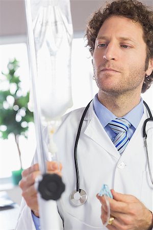simsearch:400-07334526,k - Male doctor adjusting IV drip in hospital Stock Photo - Budget Royalty-Free & Subscription, Code: 400-07334503