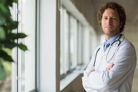 simsearch:400-07334526,k - Portrait of confident male doctor standing arms crossed in hospital Stock Photo - Budget Royalty-Free & Subscription, Code: 400-07334524
