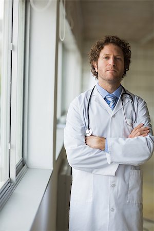 simsearch:400-07334526,k - Portrait of male doctor standing arms crossed in hospital Stock Photo - Budget Royalty-Free & Subscription, Code: 400-07334525