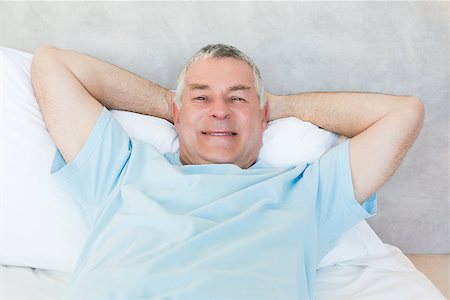 Portrait of senior man with hands behind head lying in bed Stock Photo - Budget Royalty-Free & Subscription, Code: 400-07334626
