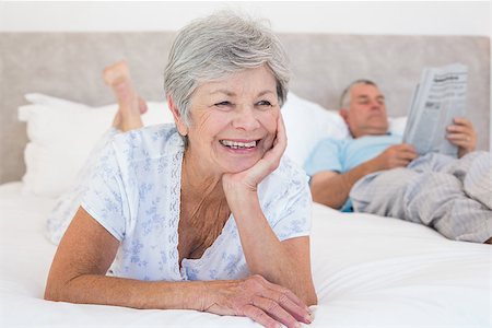 simsearch:400-07334704,k - Thoughtful senior woman with man reading newspaper on bed at home Stock Photo - Budget Royalty-Free & Subscription, Code: 400-07334656