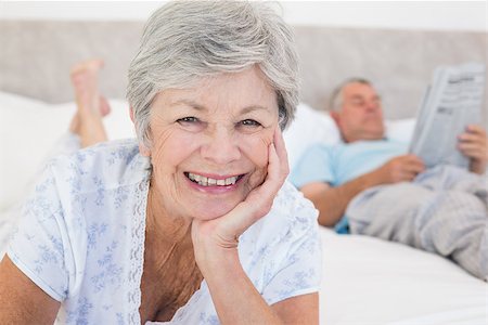 simsearch:400-07334704,k - Portrait of senior woman smiling with man in background on bed at home Stock Photo - Budget Royalty-Free & Subscription, Code: 400-07334657