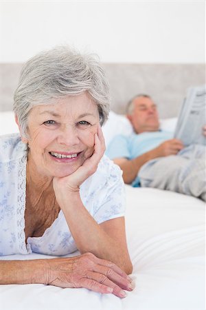 simsearch:400-07334704,k - Portrait of smiling senior woman with man in background on bed at home Stock Photo - Budget Royalty-Free & Subscription, Code: 400-07334658