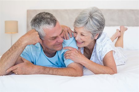 simsearch:400-07334704,k - Happy senior couple smiling together while lying on bed at home Stock Photo - Budget Royalty-Free & Subscription, Code: 400-07334650