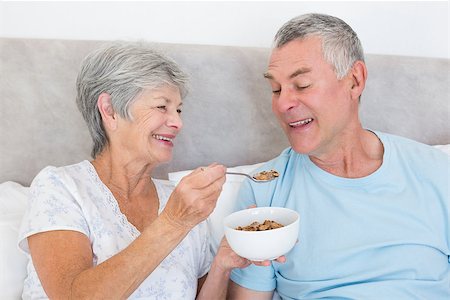 simsearch:400-07334704,k - Happy senior woman feeding cereals to husband at home Stock Photo - Budget Royalty-Free & Subscription, Code: 400-07334676
