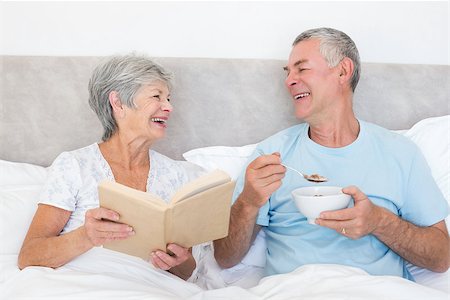 simsearch:400-07334704,k - Happy senior man having cereals while wife holding book in bed at home Stock Photo - Budget Royalty-Free & Subscription, Code: 400-07334679