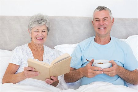 simsearch:400-07334704,k - Portrait of happy senior couple with book and cereal bowl in bed at home Stock Photo - Budget Royalty-Free & Subscription, Code: 400-07334680