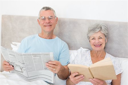 simsearch:400-07334704,k - Portrait of senior couple holding newspaper and book in bed at home Stock Photo - Budget Royalty-Free & Subscription, Code: 400-07334696
