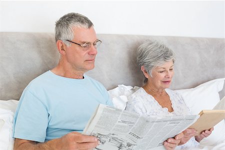 simsearch:400-07334704,k - Senior man holding newspaper with wife reading book in bed at home Stock Photo - Budget Royalty-Free & Subscription, Code: 400-07334698