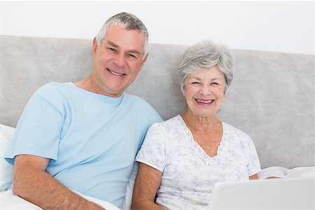 simsearch:400-07334704,k - Portrait of senior couple with laptop sitting in bed at home Stock Photo - Budget Royalty-Free & Subscription, Code: 400-07334690