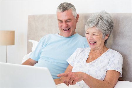 simsearch:400-07334704,k - Senior couple laughing while using laptop in bed at home Stock Photo - Budget Royalty-Free & Subscription, Code: 400-07334691