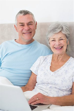 simsearch:400-07334704,k - Portrait of happy senior couple with laptop in bed at home Stock Photo - Budget Royalty-Free & Subscription, Code: 400-07334693