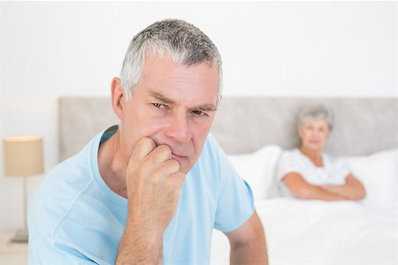 simsearch:400-07334704,k - Thoughtful senior man looking away with woman in background at home Stock Photo - Budget Royalty-Free & Subscription, Code: 400-07334702