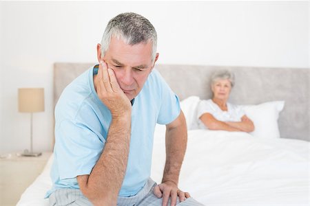 simsearch:400-07334704,k - Disappointed senior man with woman in background at home Stock Photo - Budget Royalty-Free & Subscription, Code: 400-07334703