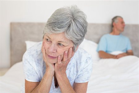simsearch:400-07334704,k - Sad senior woman looking away with man in background on bed at home Stock Photo - Budget Royalty-Free & Subscription, Code: 400-07334710