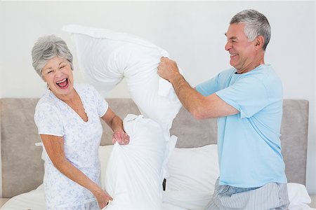 simsearch:400-07334704,k - Happy senior couple having pillow fight in bed at home Stock Photo - Budget Royalty-Free & Subscription, Code: 400-07334711