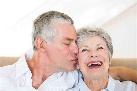simsearch:400-07334704,k - Senior man kissing happy wife sitting on sofa at home Stock Photo - Budget Royalty-Free & Subscription, Code: 400-07334725