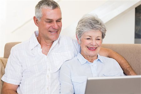 simsearch:400-07334704,k - Senior couple using laptop together while sitting on sofa at home Stock Photo - Budget Royalty-Free & Subscription, Code: 400-07334726