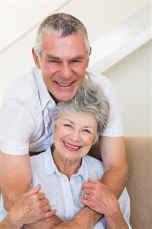 simsearch:400-04151970,k - Portrait of happy senior man embracing wife on sofa at home Fotografie stock - Microstock e Abbonamento, Codice: 400-07334735