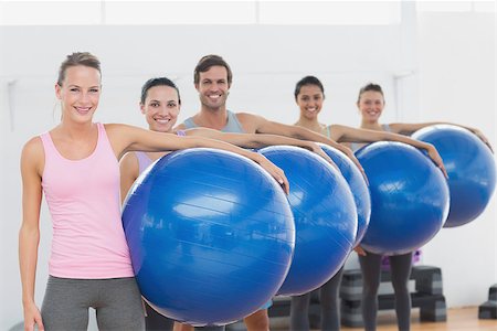 Portrait of an instructor and fitness class holding exercise balls at fitness studio Stock Photo - Budget Royalty-Free & Subscription, Code: 400-07334835