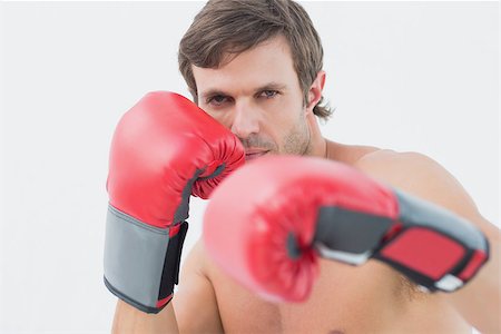 simsearch:400-06876600,k - Portrait of a serious young man in red boxing gloves over white background Stock Photo - Budget Royalty-Free & Subscription, Code: 400-07335194