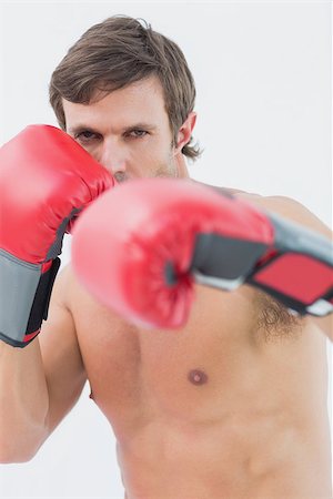 simsearch:400-06876600,k - Portrait of a serious young man in red boxing gloves over white background Stock Photo - Budget Royalty-Free & Subscription, Code: 400-07335195