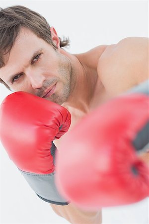 simsearch:400-06876600,k - Portrait of a serious young man in red boxing gloves over white background Stock Photo - Budget Royalty-Free & Subscription, Code: 400-07335196