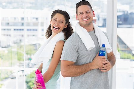 Portrait of cheerful couple with towels and water bottles at gym Stock Photo - Budget Royalty-Free & Subscription, Code: 400-07335229