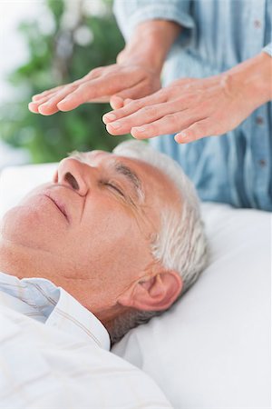 simsearch:400-07335332,k - Senior man having Reiki treatment by massage therapist at spa Fotografie stock - Microstock e Abbonamento, Codice: 400-07335329