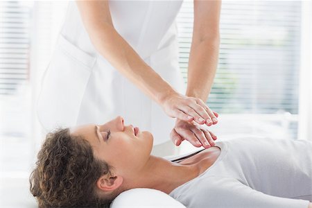 simsearch:400-07335332,k - Female therapist performing Reiki over woman at health spa Fotografie stock - Microstock e Abbonamento, Codice: 400-07335375