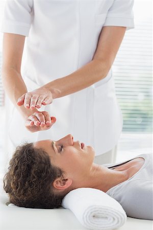 simsearch:400-07335332,k - Female therapist performing Reiki over woman at spa Fotografie stock - Microstock e Abbonamento, Codice: 400-07335376