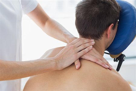 simsearch:400-07335332,k - Rear view of man receiving shoulder massage by female therapist in hospital Fotografie stock - Microstock e Abbonamento, Codice: 400-07335427