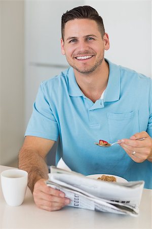 Portrait of happy man with newspaper having breakfast at table in kitchen Stock Photo - Budget Royalty-Free & Subscription, Code: 400-07335515