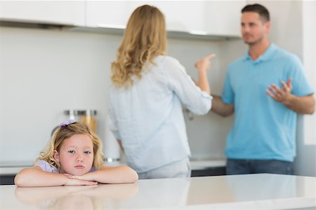 Portrait of sad girl leaning on table while parents arguing in background at home Stock Photo - Budget Royalty-Free & Subscription, Code: 400-07335525