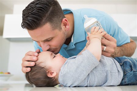 family front house - Loving father kissing baby boy on forehead at kitchen counter Photographie de stock - Aubaine LD & Abonnement, Code: 400-07335705