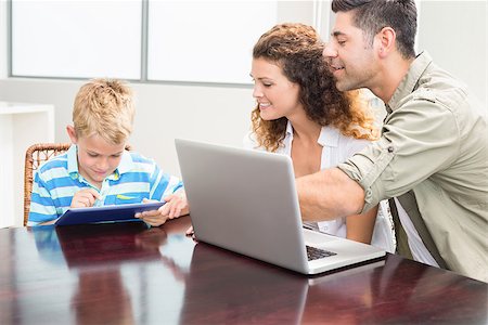 simsearch:400-07664794,k - Happy parents showing son how to use tablet pc at home in kitchen Stock Photo - Budget Royalty-Free & Subscription, Code: 400-07336230