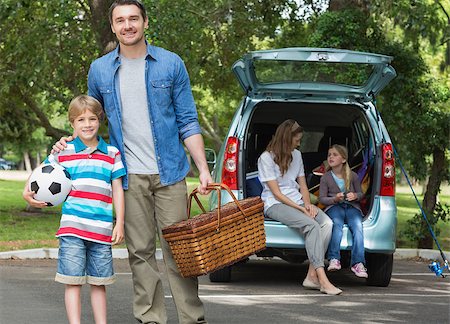 Portrait of father and son with picnic basket while mother and daughter sitting in car trunk Stock Photo - Budget Royalty-Free & Subscription, Code: 400-07336865