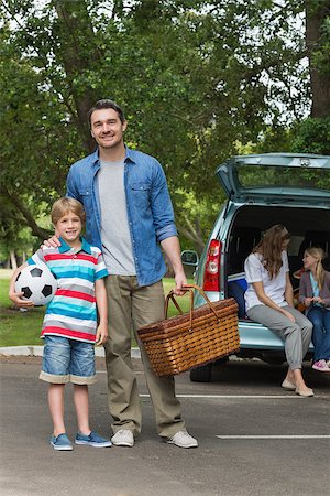 Portrait of father and son with picnic basket while mother and daughter sitting in car trunk Stock Photo - Budget Royalty-Free & Subscription, Code: 400-07336866