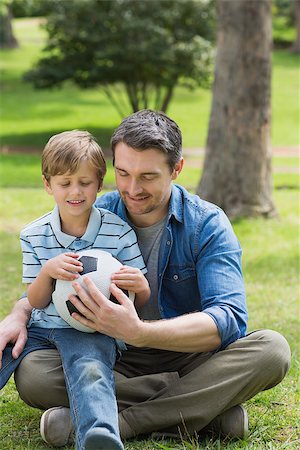 soccer boy length - Full length of a father and son sitting with ball at the park Stock Photo - Budget Royalty-Free & Subscription, Code: 400-07336927