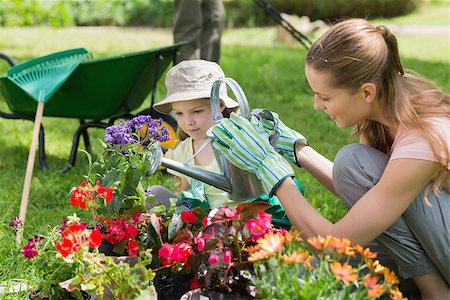 Side view of a mother and daughter watering plants at the garden Foto de stock - Super Valor sin royalties y Suscripción, Código: 400-07336951