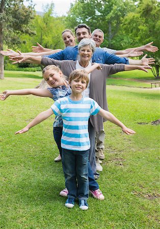 Portrait of a happy extended family standing in row with arms outstretched at the park Stock Photo - Budget Royalty-Free & Subscription, Code: 400-07336995