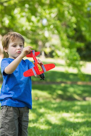 simsearch:400-07474903,k - Cute young boy with toy aeroplane standing at the park Foto de stock - Super Valor sin royalties y Suscripción, Código: 400-07337046