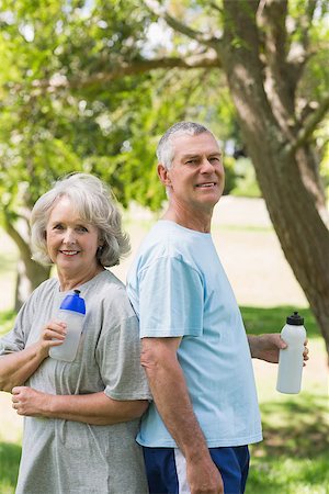 Portrait of a smiling mature couple standing with water bottles at the park Stock Photo - Budget Royalty-Free & Subscription, Code: 400-07337064